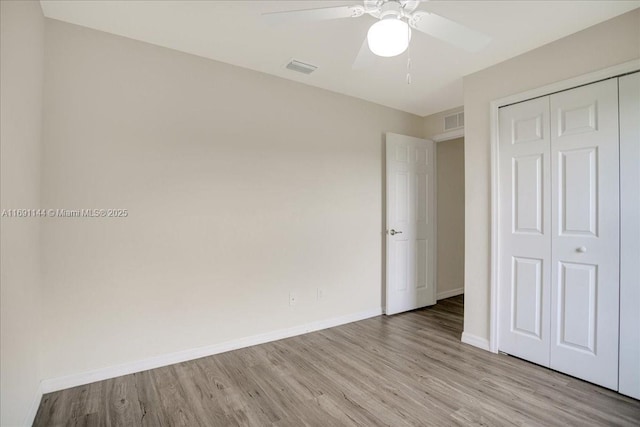 unfurnished bedroom featuring ceiling fan, a closet, and light hardwood / wood-style flooring