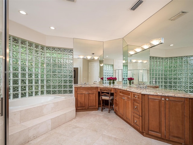 bathroom featuring tile patterned flooring, plenty of natural light, vanity, and a relaxing tiled tub