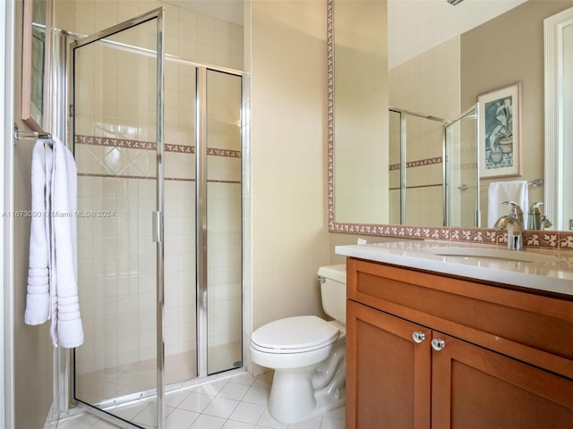 bathroom with vanity, a shower with door, tile patterned floors, and toilet