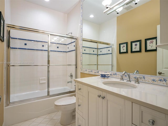 full bathroom with tile patterned flooring, vanity, combined bath / shower with glass door, and toilet