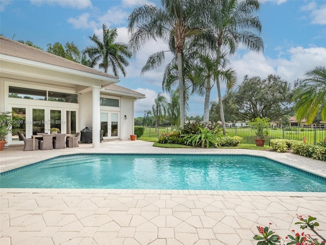 view of swimming pool with a patio, french doors, and grilling area