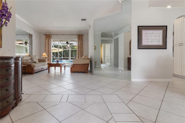 living room with ornamental molding, light tile patterned floors, and baseboards