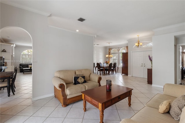living room with a chandelier, light tile patterned floors, crown molding, plenty of natural light, and baseboards