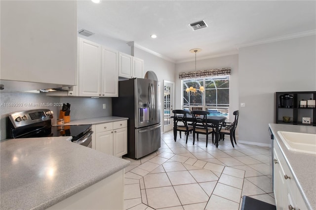 kitchen with appliances with stainless steel finishes, crown molding, white cabinetry, light tile patterned floors, and light countertops