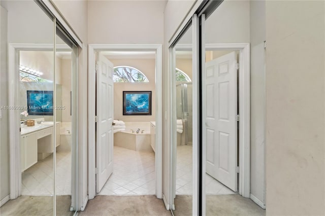 corridor with light carpet and light tile patterned flooring