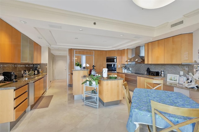 kitchen featuring wall chimney exhaust hood, light tile patterned flooring, a kitchen island, and backsplash