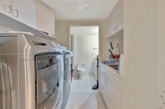 laundry room with cabinets, separate washer and dryer, and light tile patterned floors