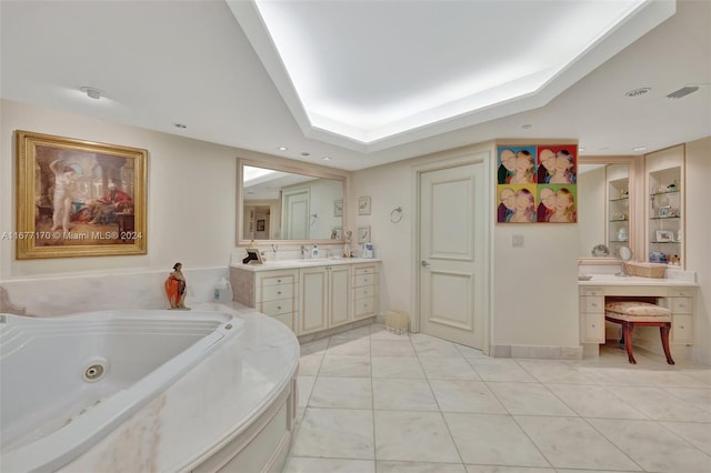 bathroom featuring tile patterned floors, vanity, a tub to relax in, and a raised ceiling