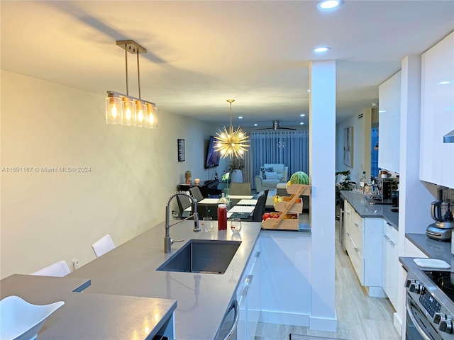 kitchen featuring decorative light fixtures, white cabinetry, and sink