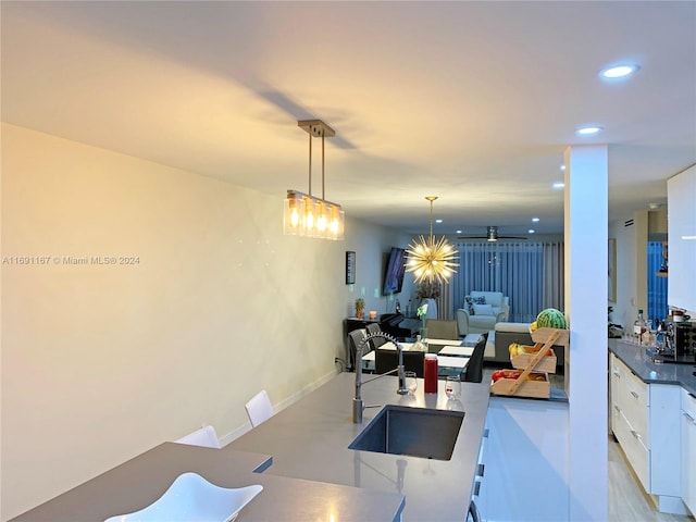 kitchen with white cabinetry, sink, and pendant lighting