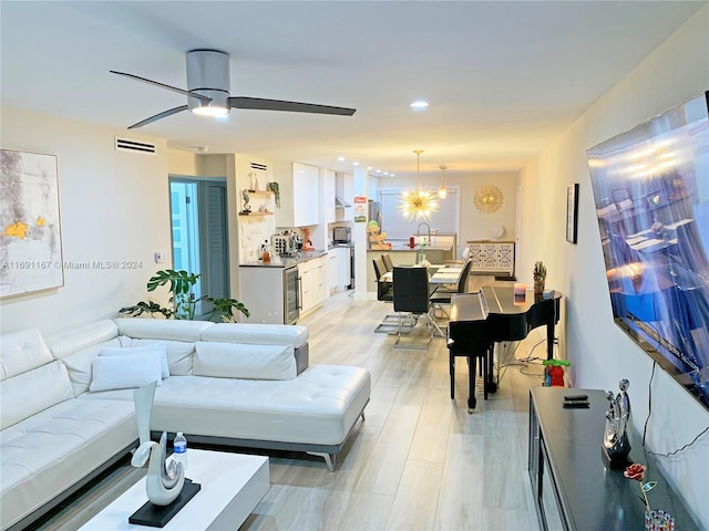 living room with ceiling fan and light hardwood / wood-style floors