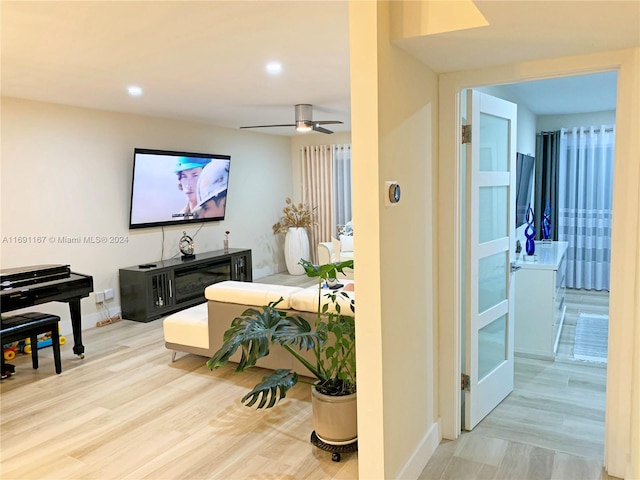 living room featuring light wood-type flooring and ceiling fan