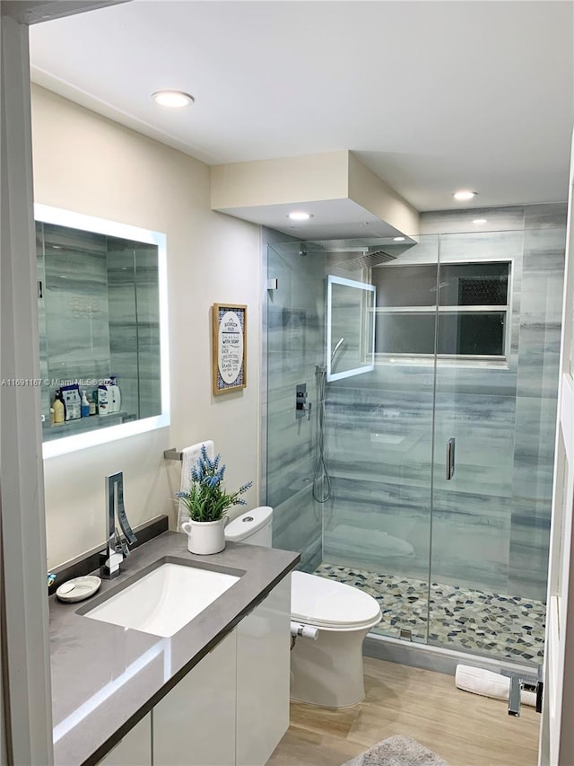 bathroom with vanity, hardwood / wood-style flooring, toilet, and walk in shower