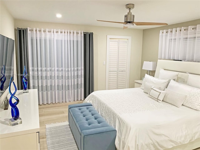 bedroom featuring ceiling fan, a closet, and light hardwood / wood-style floors