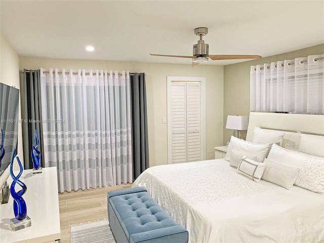 bedroom featuring ceiling fan, light hardwood / wood-style floors, and a closet