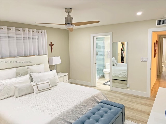 bedroom with ceiling fan, light wood-type flooring, and ensuite bath