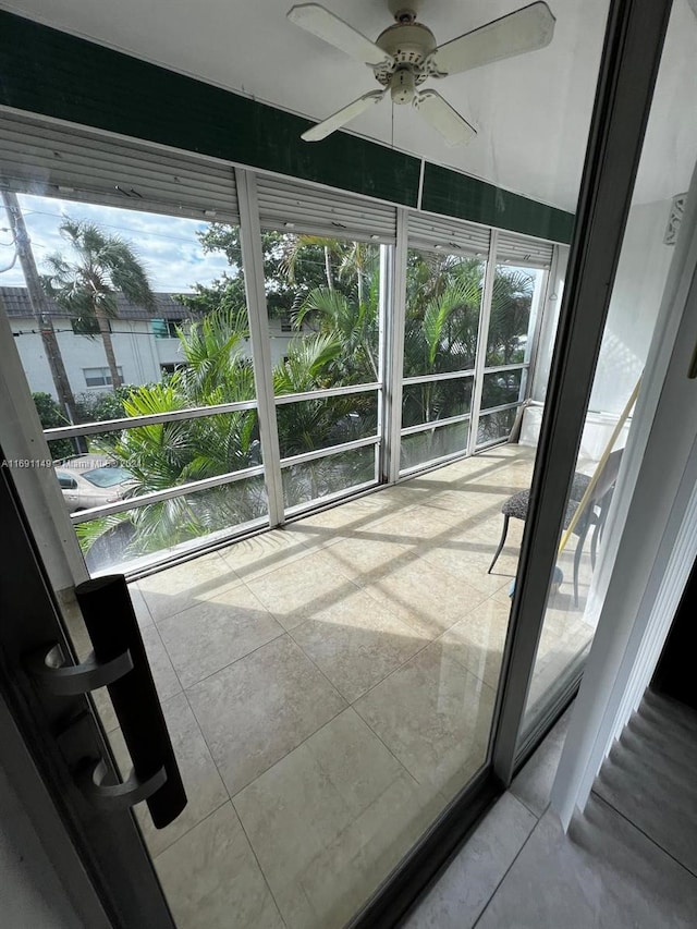 unfurnished sunroom with ceiling fan