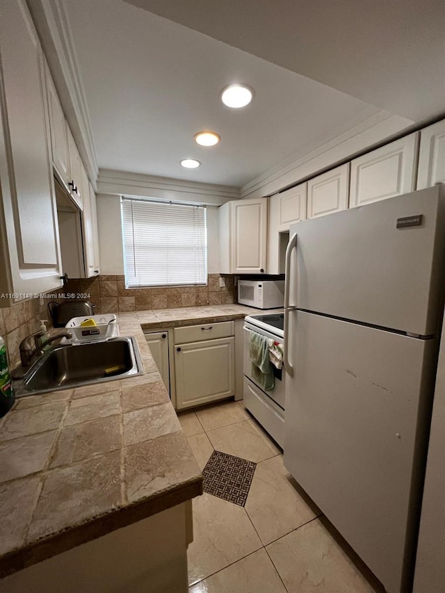 kitchen with white cabinets, sink, white appliances, and crown molding