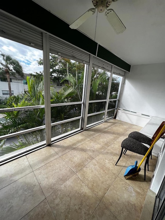 unfurnished sunroom featuring ceiling fan