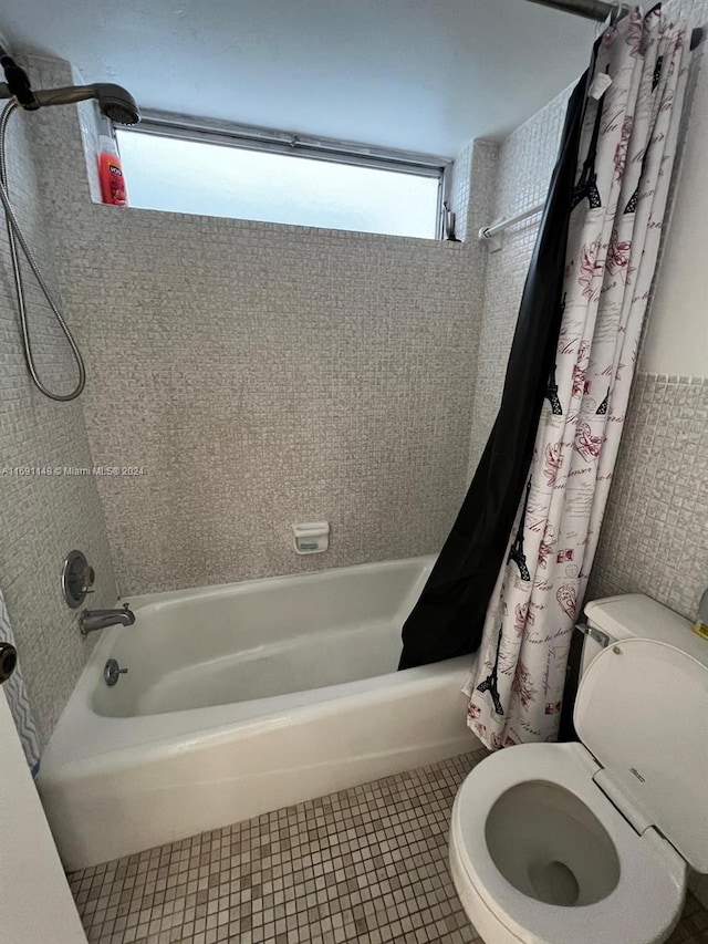 bathroom with toilet, shower / bath combo, and tile patterned floors