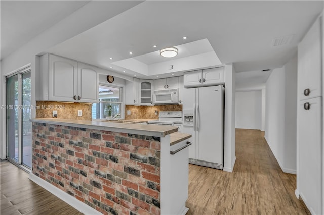 kitchen with white appliances, a healthy amount of sunlight, white cabinetry, and kitchen peninsula