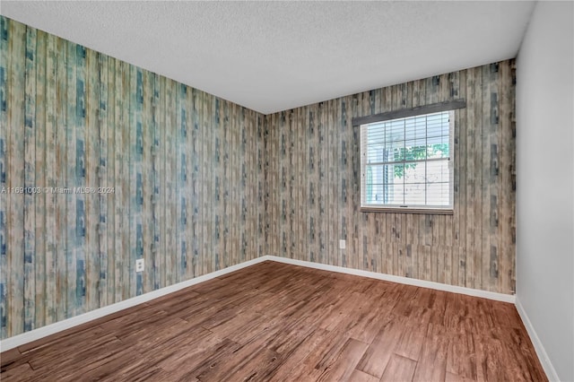 spare room with wood-type flooring and a textured ceiling