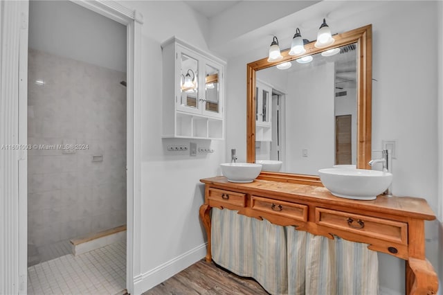 bathroom featuring tiled shower, hardwood / wood-style flooring, and vanity