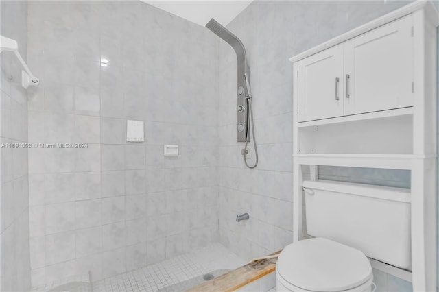 bathroom featuring tiled shower and toilet