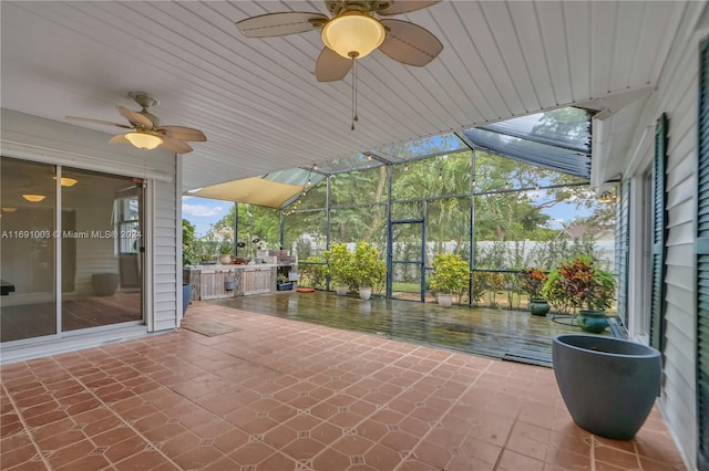 view of patio with ceiling fan and glass enclosure