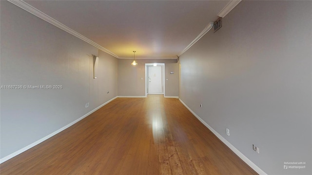 empty room featuring wood-type flooring and crown molding