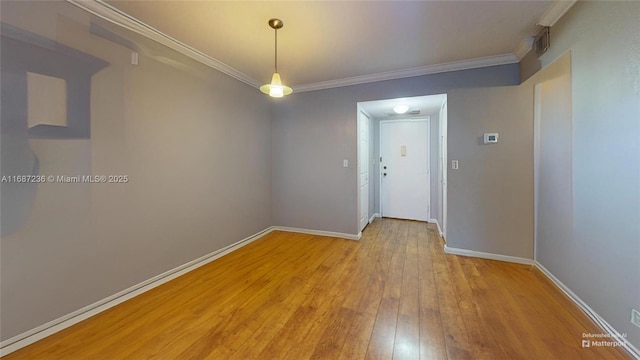 empty room featuring ornamental molding and light hardwood / wood-style flooring