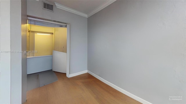 empty room featuring hardwood / wood-style flooring and crown molding