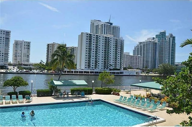 view of pool featuring a water view and a patio