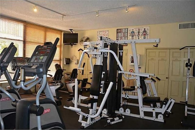 exercise room featuring a textured ceiling