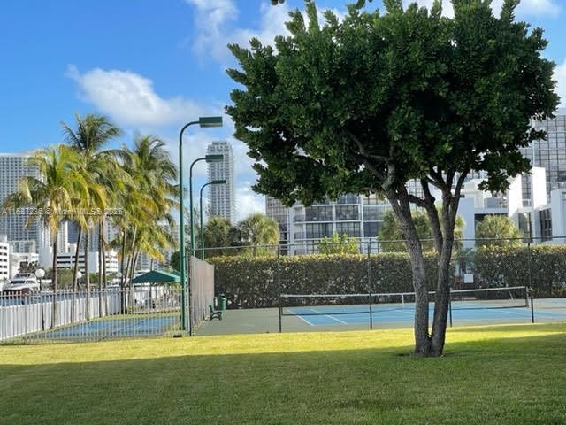 view of tennis court featuring a lawn