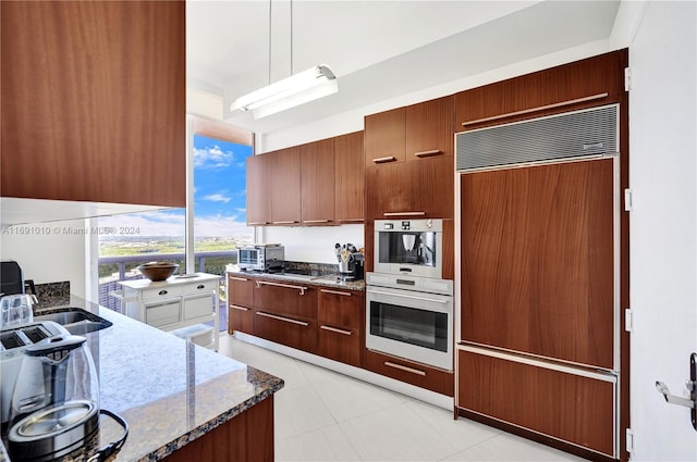 kitchen with dark stone countertops, sink, and appliances with stainless steel finishes