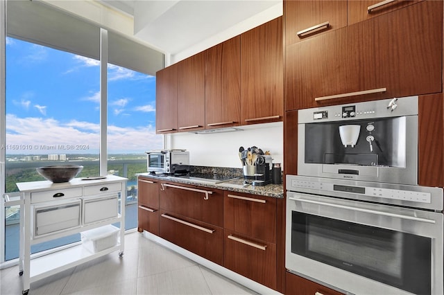 kitchen with white gas stovetop, stainless steel oven, and stone countertops