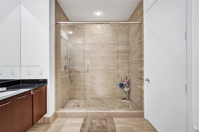 bathroom with vanity and a shower with shower door