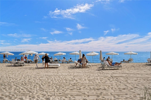 view of playground featuring a beach view and a water view