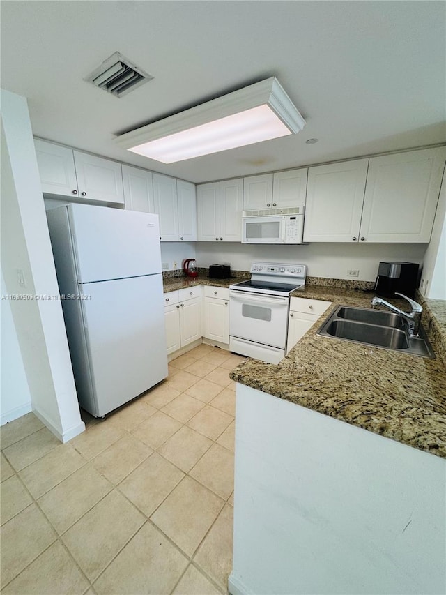 kitchen featuring white cabinets, sink, white appliances, and light tile patterned flooring