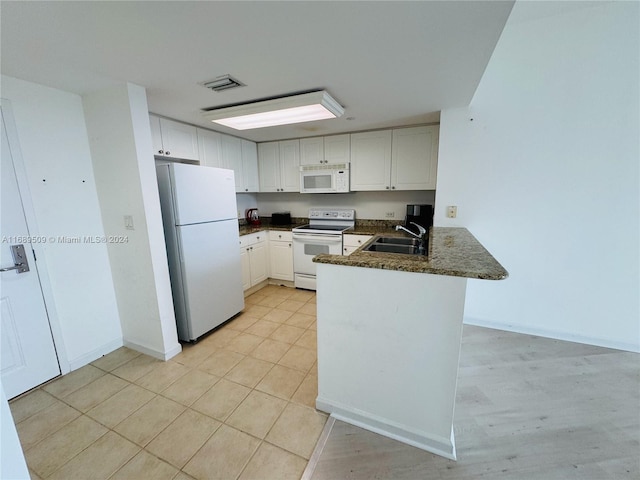 kitchen with white cabinets, kitchen peninsula, sink, light hardwood / wood-style flooring, and white appliances