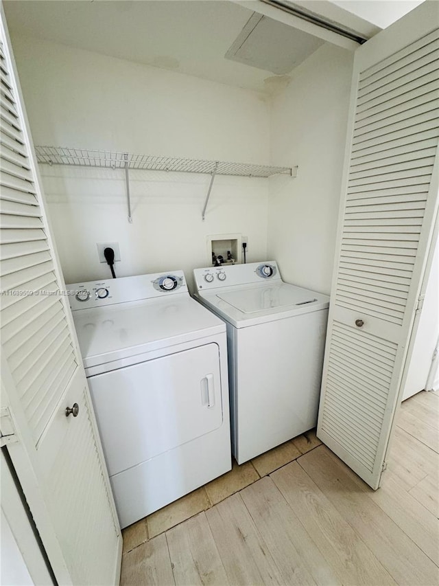 laundry room featuring light hardwood / wood-style floors and washer and dryer