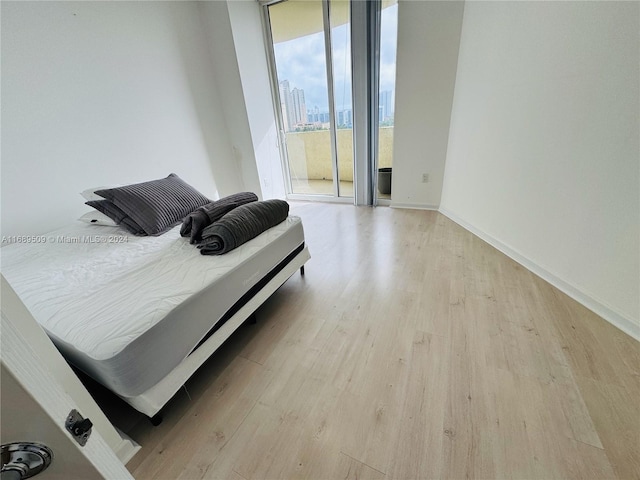 bedroom with light hardwood / wood-style flooring and access to outside