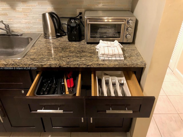 room details with light tile patterned floors, stone countertops, sink, and tasteful backsplash