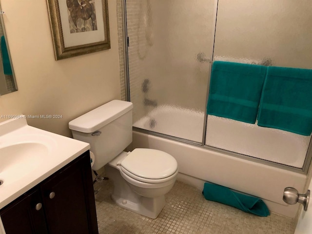 full bathroom featuring tile patterned flooring, vanity, combined bath / shower with glass door, and toilet