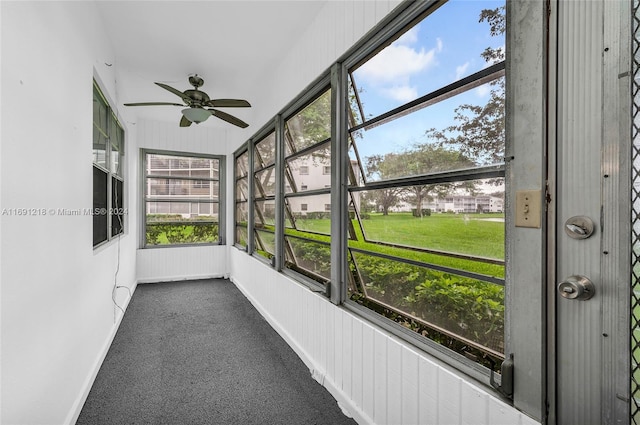 unfurnished sunroom featuring ceiling fan