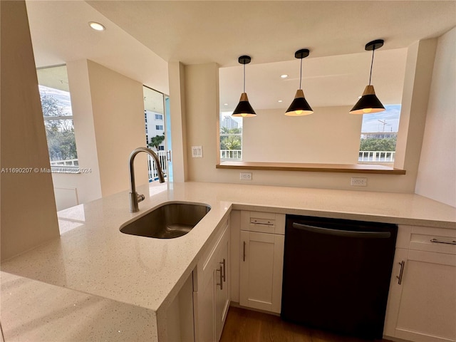 kitchen with a healthy amount of sunlight, sink, light stone counters, and black dishwasher