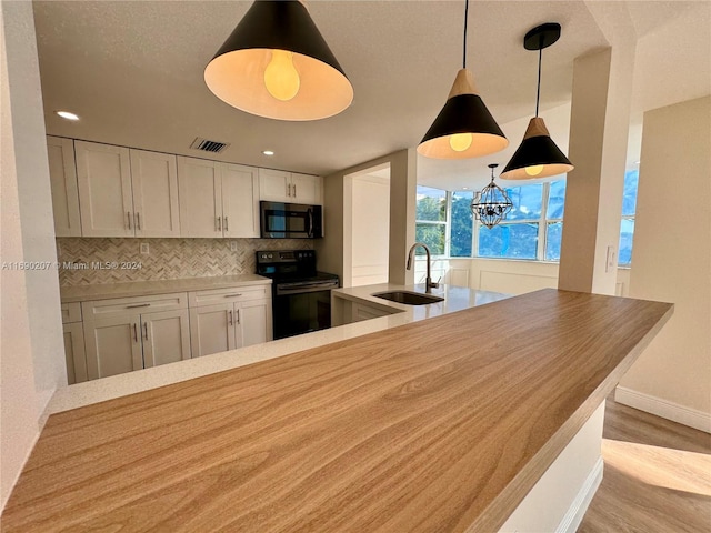 kitchen featuring white cabinetry, sink, backsplash, light hardwood / wood-style flooring, and black range with electric stovetop