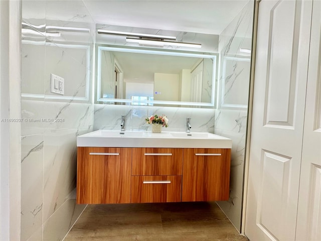 bathroom with tile walls, vanity, and hardwood / wood-style floors