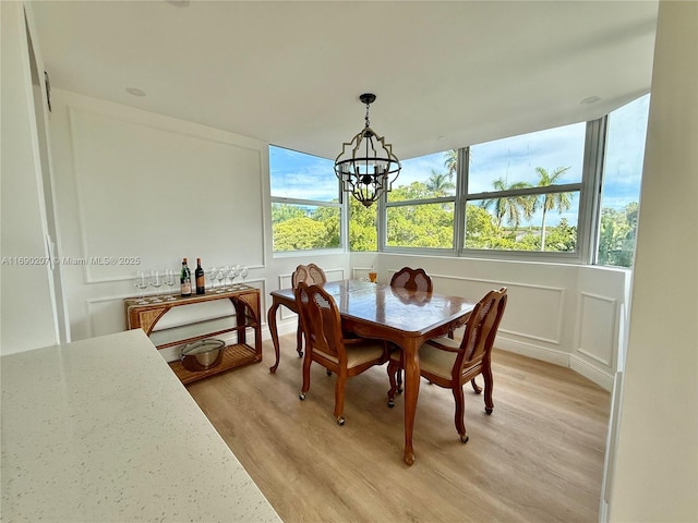 16546 NE 26th Ave Unit 3G, North Miami Beach, FL 33160 - dining room with a decorative wall, light wood-type flooring, and a chandelier